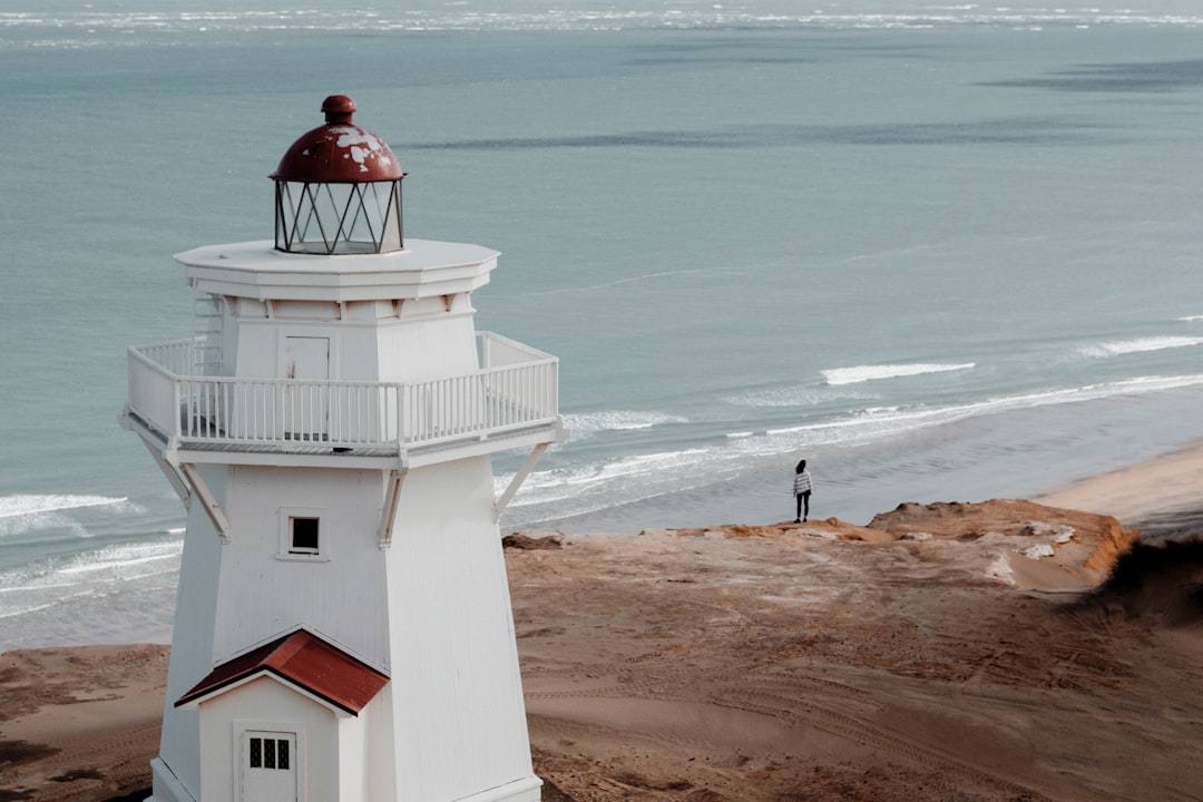 white concrete lighthouse near body of water during daytime