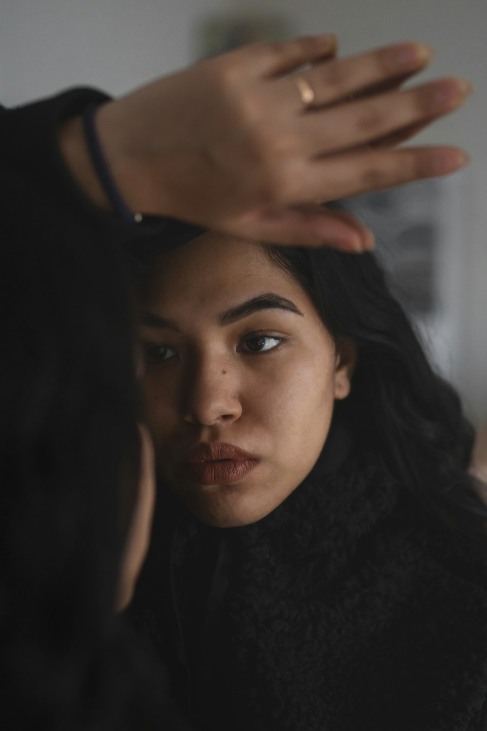 woman in black shirt covering her face