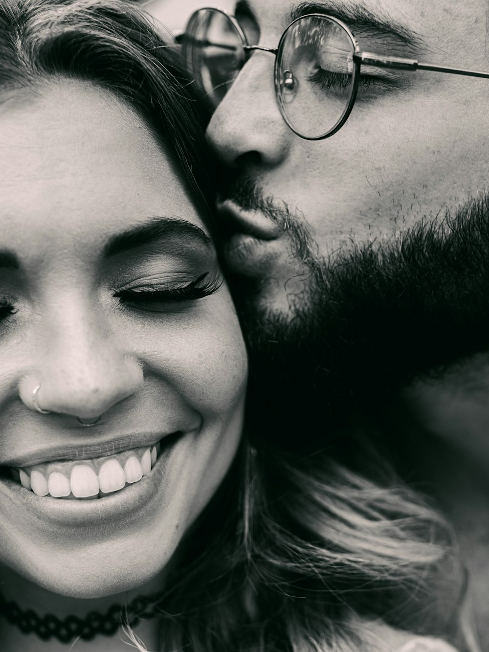 man and woman smiling in grayscale photography