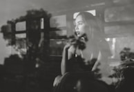 An intimate shot of Carole reflecting quietly by a window, capturing a moment of purpose and calm.