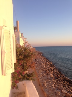 A serene view of the historic baglio framed by blooming botanical gardens at sunset