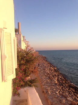 A serene image of Santorini’s sunset viewed from a quiet, less-traveled spot with soft stone grey tones