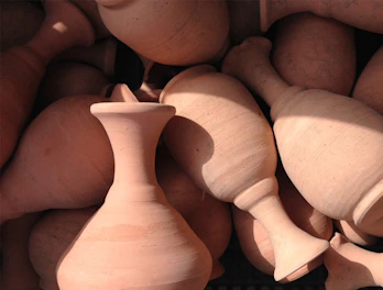 Close-up of textured stoneware vases with rich earthy glazes.