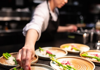 person in white shirt slicing vegetable