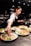 person in white shirt slicing vegetable