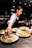 person in white shirt slicing vegetable