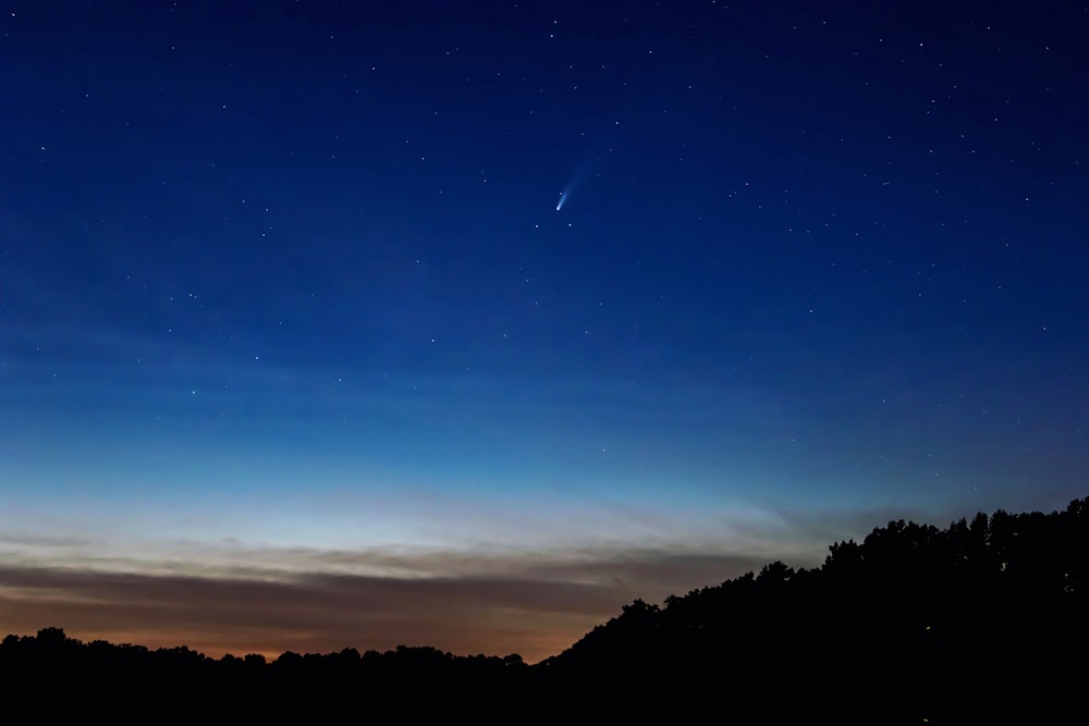 silhouette of mountain under blue sky during night time