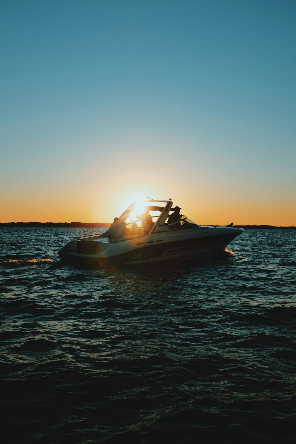 brown and white boat on sea during sunset