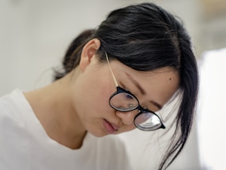 woman in white crew neck shirt wearing silver framed eyeglasses