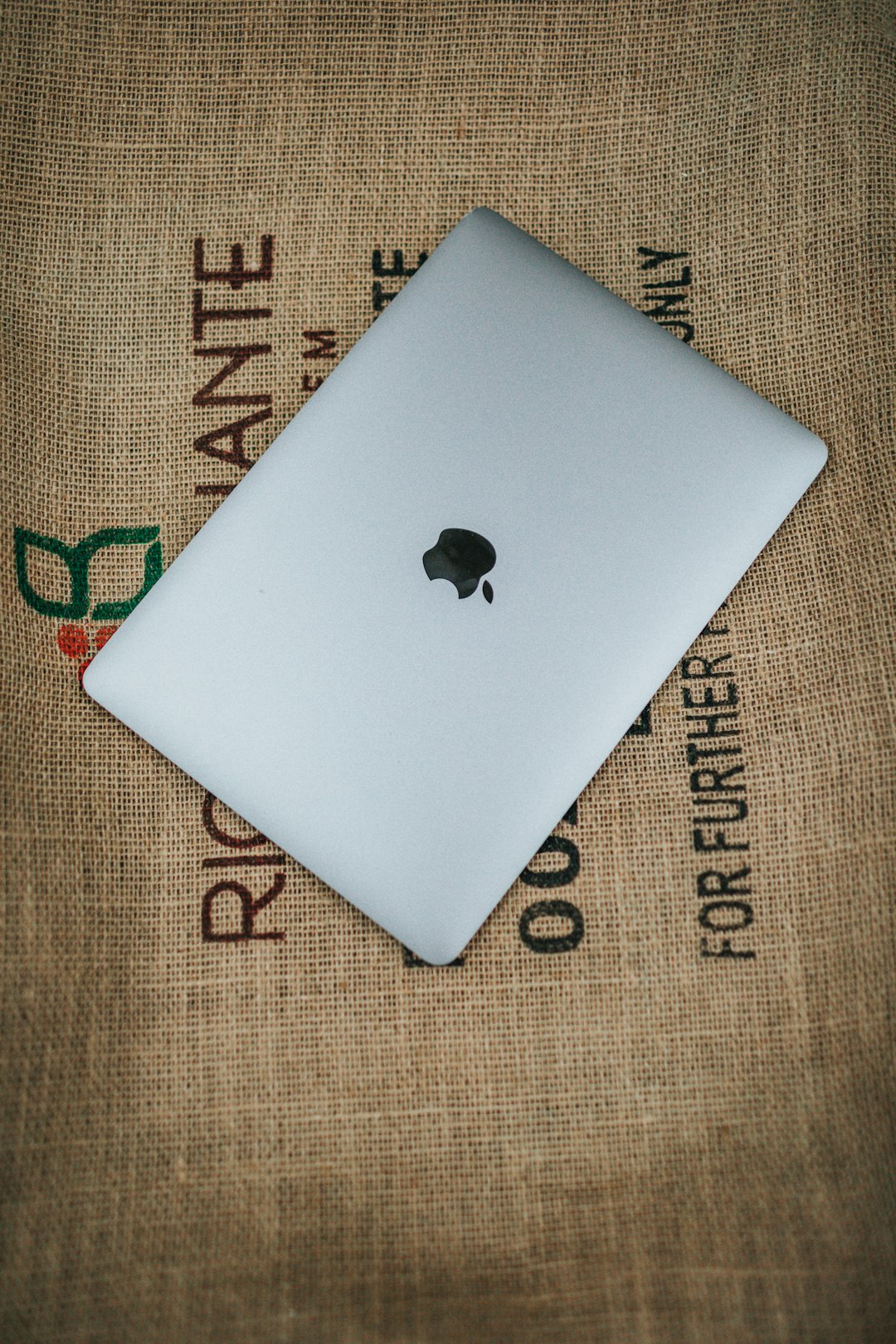 silver macbook on brown textile