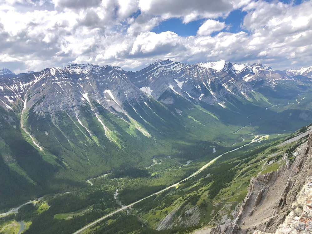 green and white mountains under white clouds and blue sky during daytime