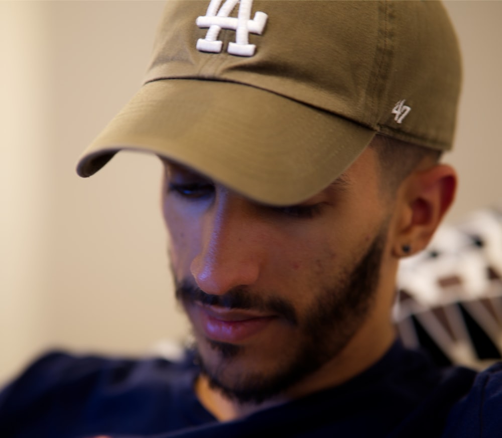 man in blue and white crew neck shirt wearing brown cap