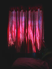 Luxurious room bathed in deep red light with shadows dancing on textured walls.