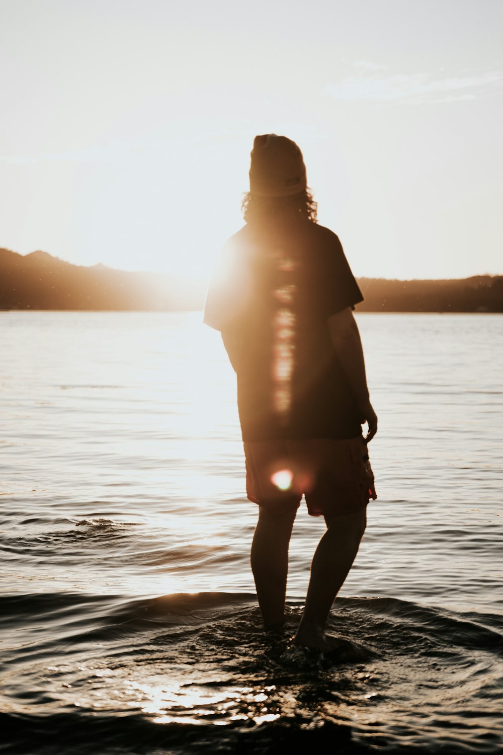 silhouette di donna in piedi sull'acqua durante il giorno