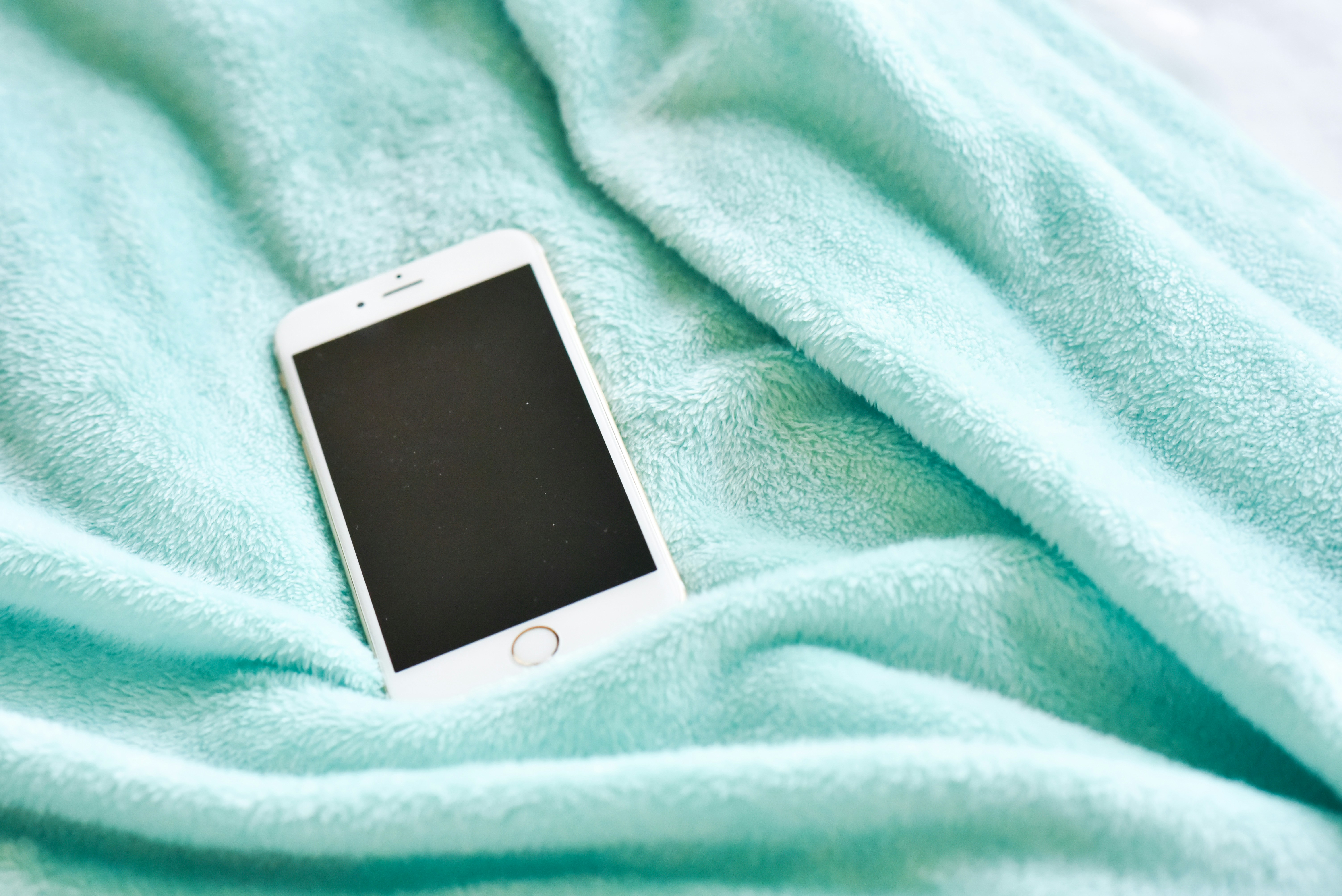 white iphone 5 on green textile