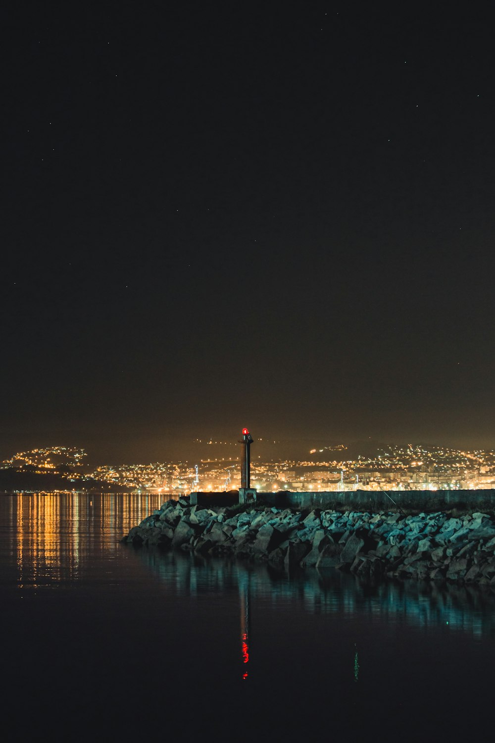 body of water near city buildings during night time