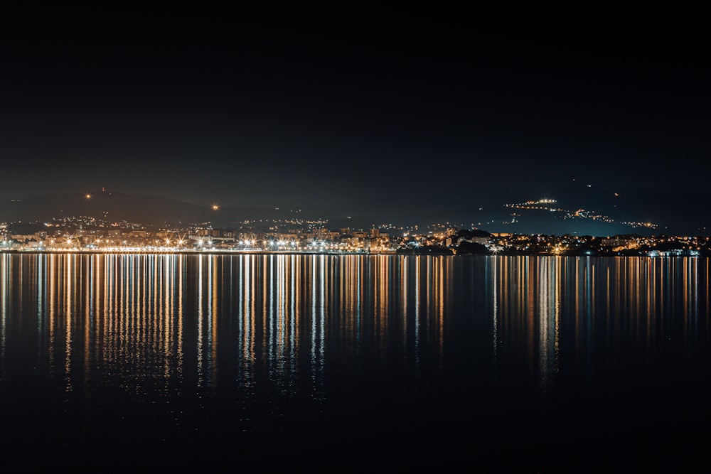 Le luci della città si riflettono sull'acqua durante la notte