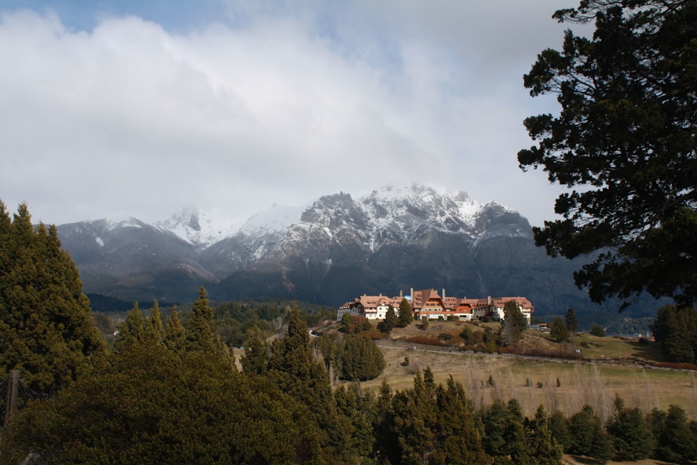 árboles verdes cerca de la montaña bajo nubes blancas durante el día