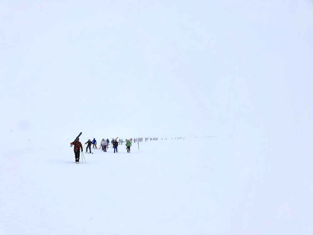 people walking on snow covered field during daytime