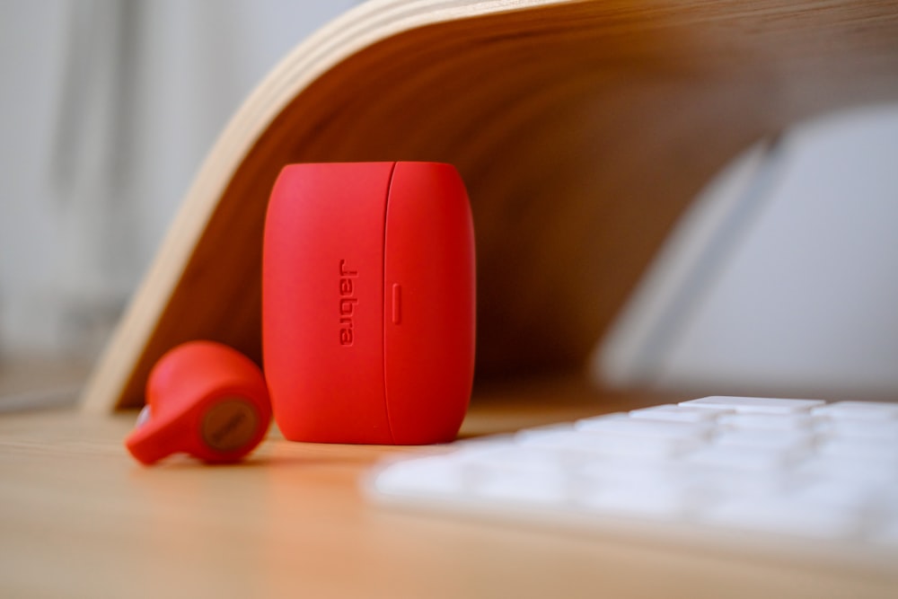 red and white plastic case on brown wooden table