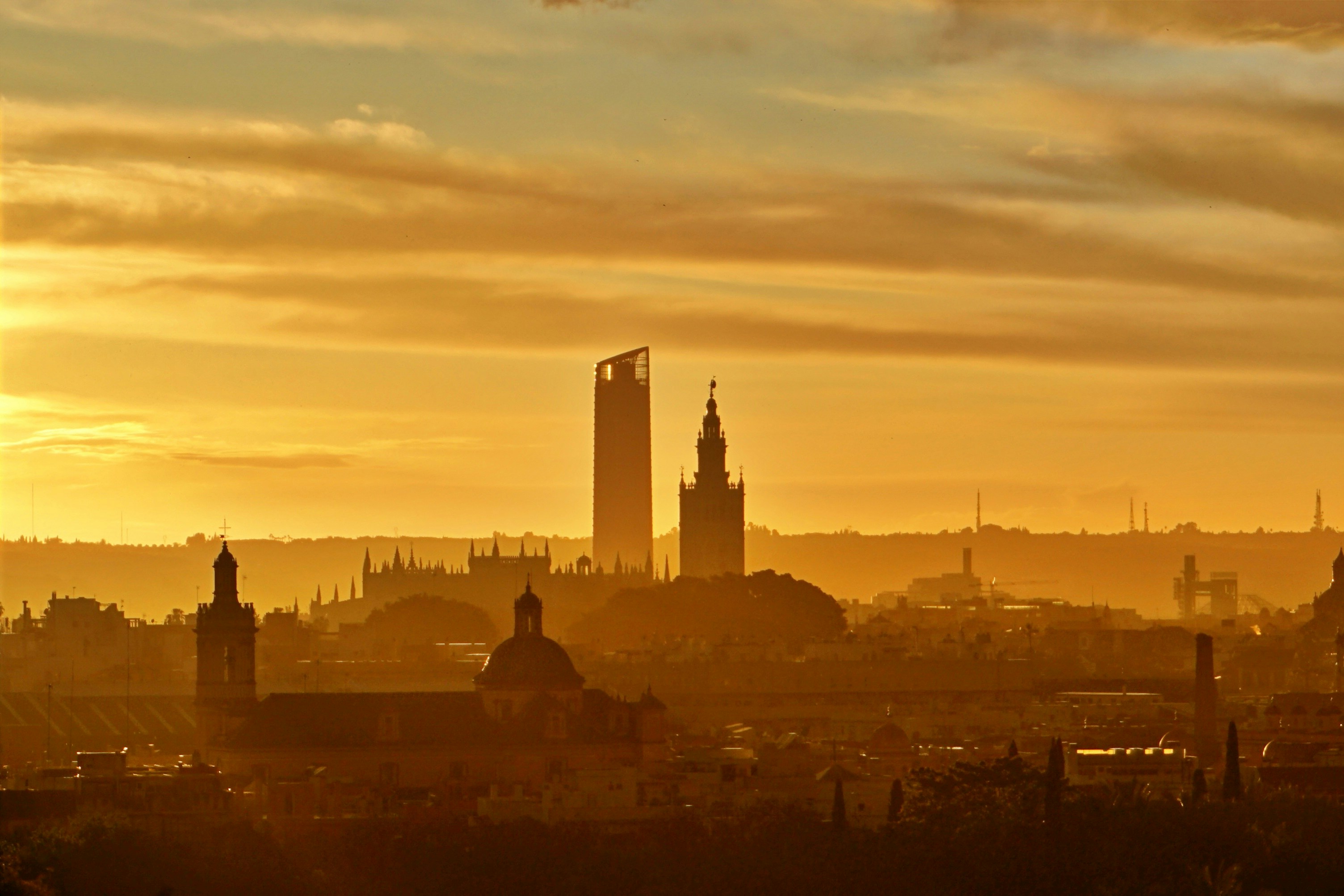 silhouette of city buildings during sunset, Skyscraper and cathedral on sunset after a rainy day.