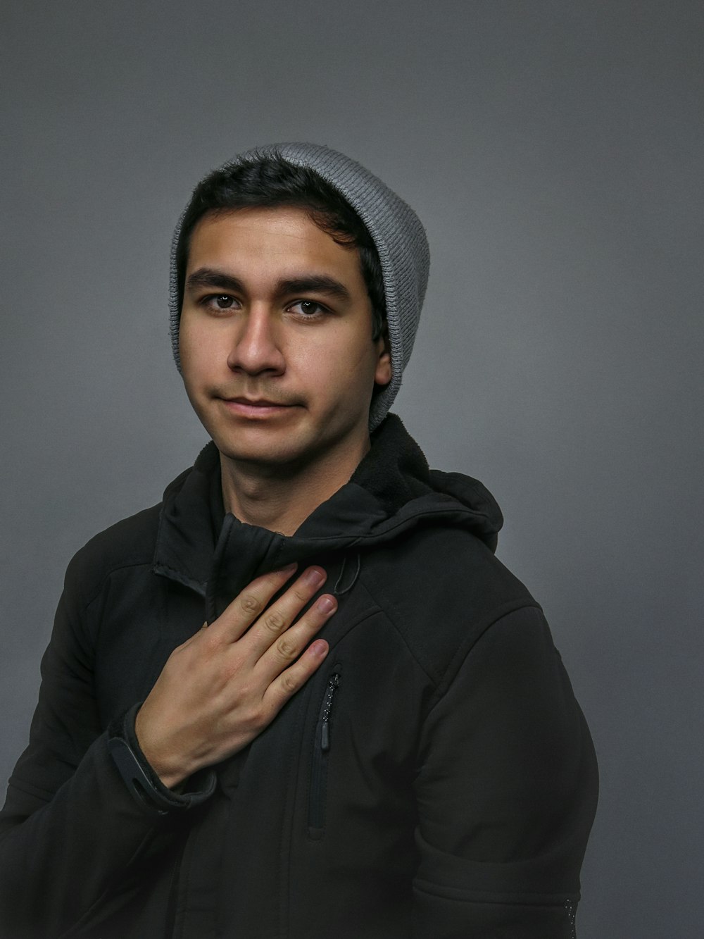 man in black hoodie and gray knit cap