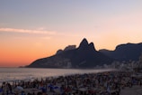 A panoramic view of a popular Chilean beach with windsurfers catching the ocean breeze under a sunset sky.