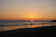 A tranquil beach at sunset with people relaxing.