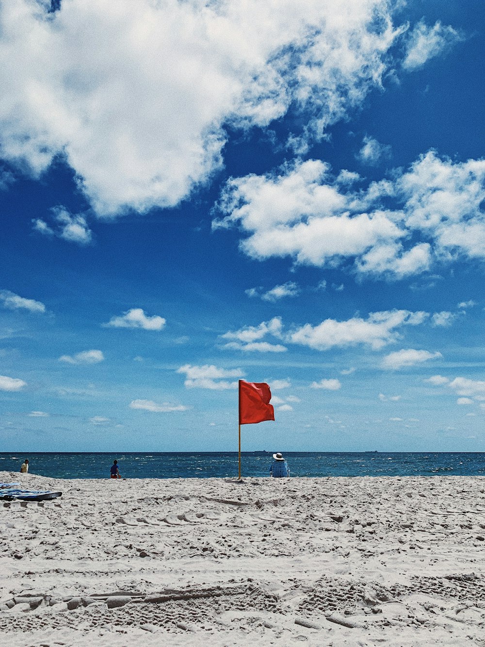 red flag on white sand beach during daytime