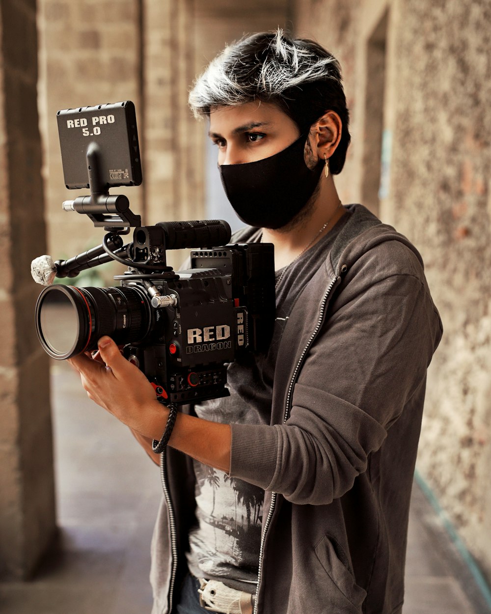 man in black knit cap and brown jacket holding black dslr camera