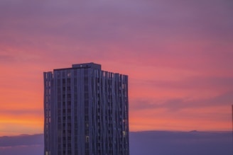 A completed landmark building against a sunset backdrop.