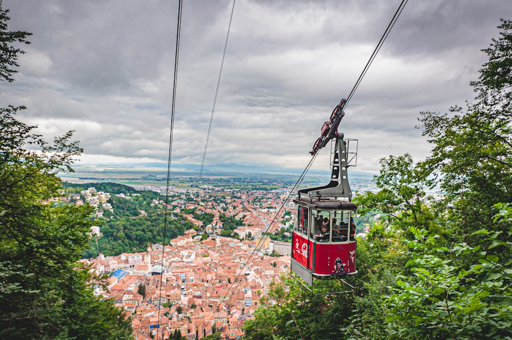 red cable car over city buildings during daytime