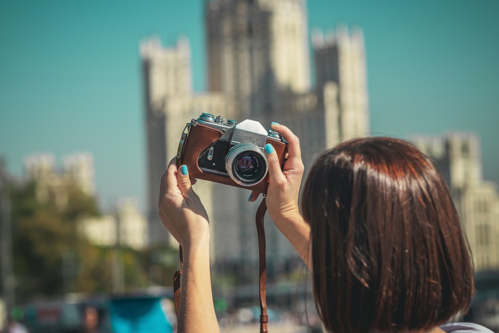 woman holding black and silver camera