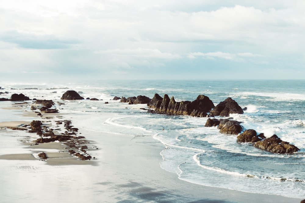 a view of a beach with rocks and water