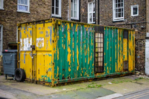 A sturdy used maritime container showing signs of character and history, placed in an industrial yard.