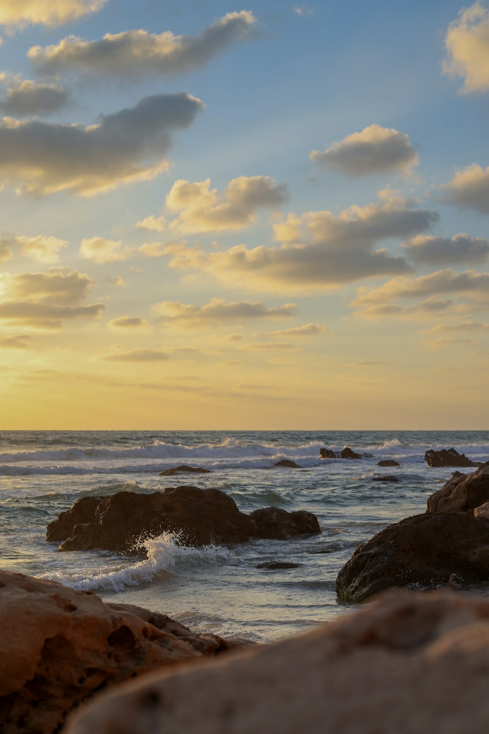 rocky shore under cloudy sky during daytime