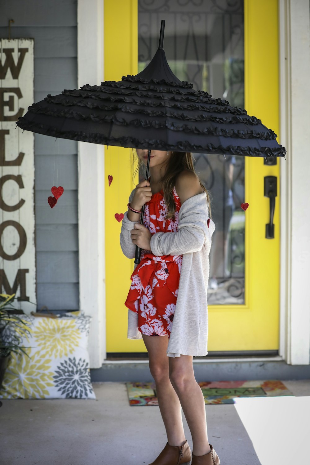 girl in white and red floral dress holding umbrella