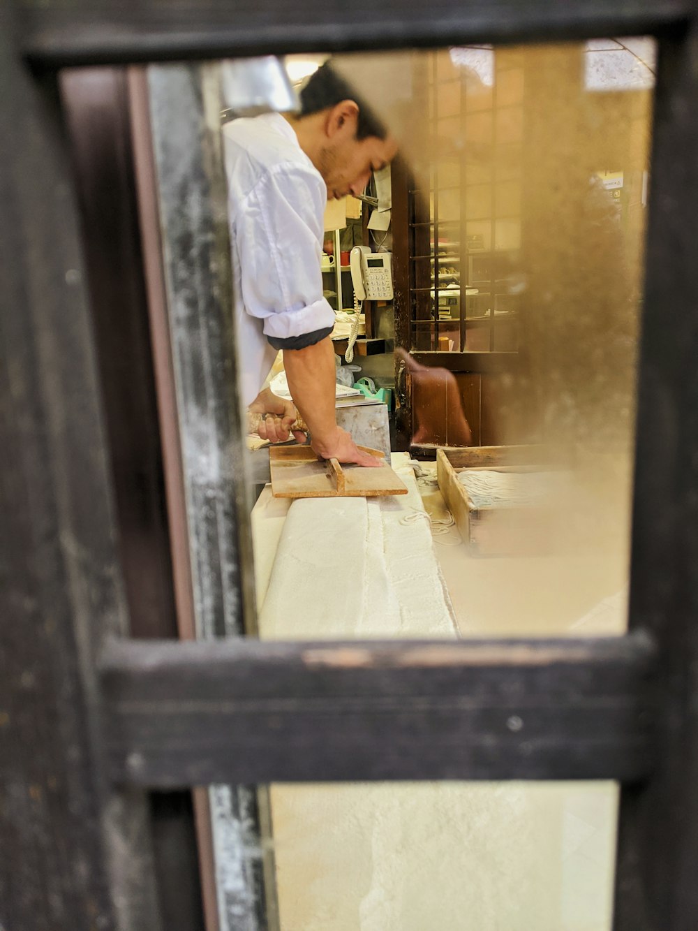 woman in white shirt standing near brown wooden table