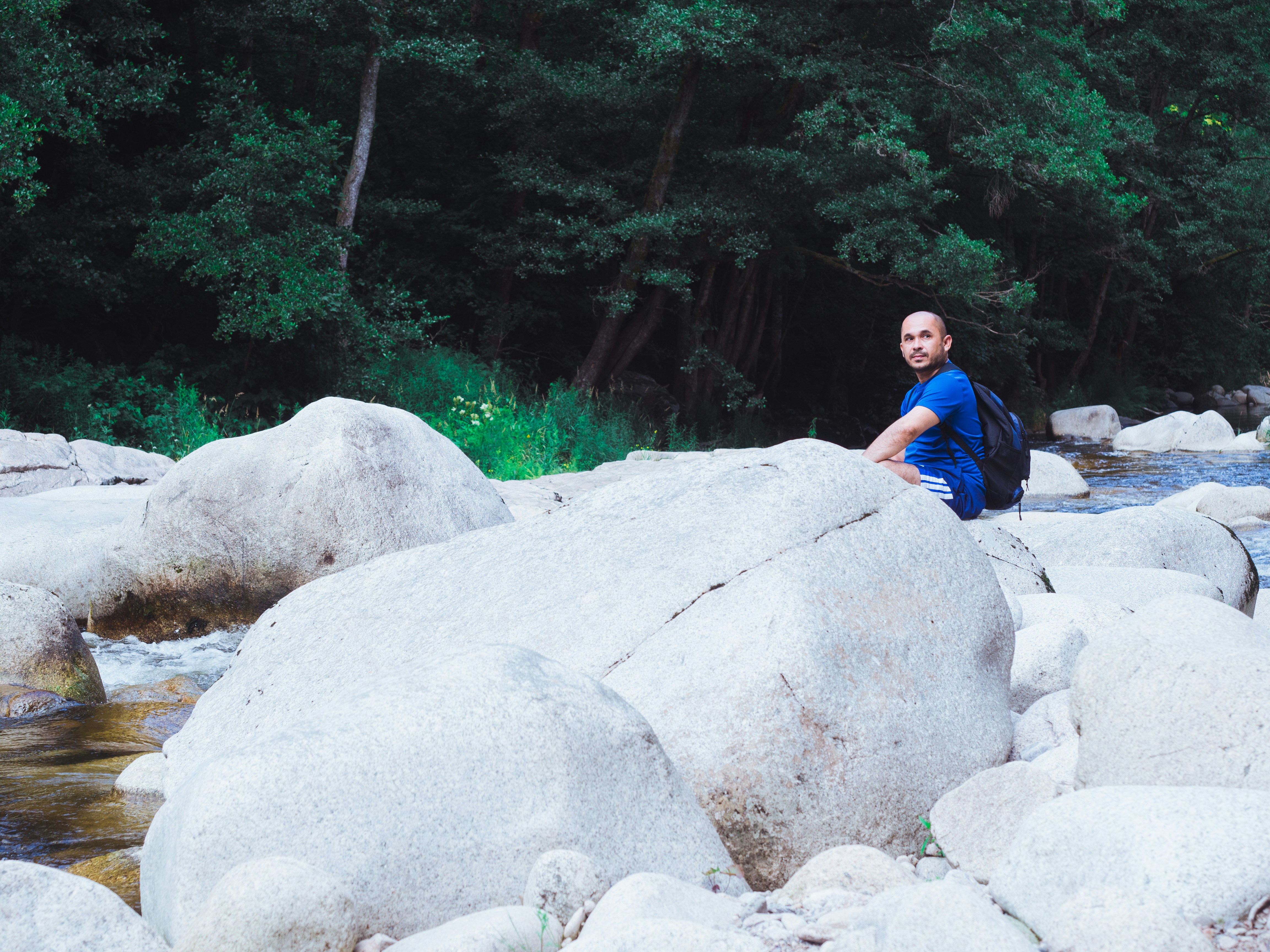 Man sitting on gray rock in contemplation
