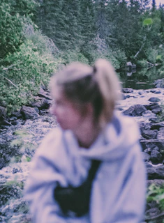 woman in gray hoodie standing on rocky road during daytime