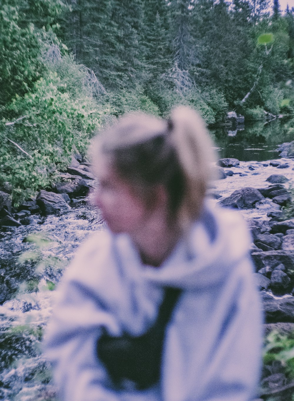 woman in gray hoodie standing on rocky road during daytime