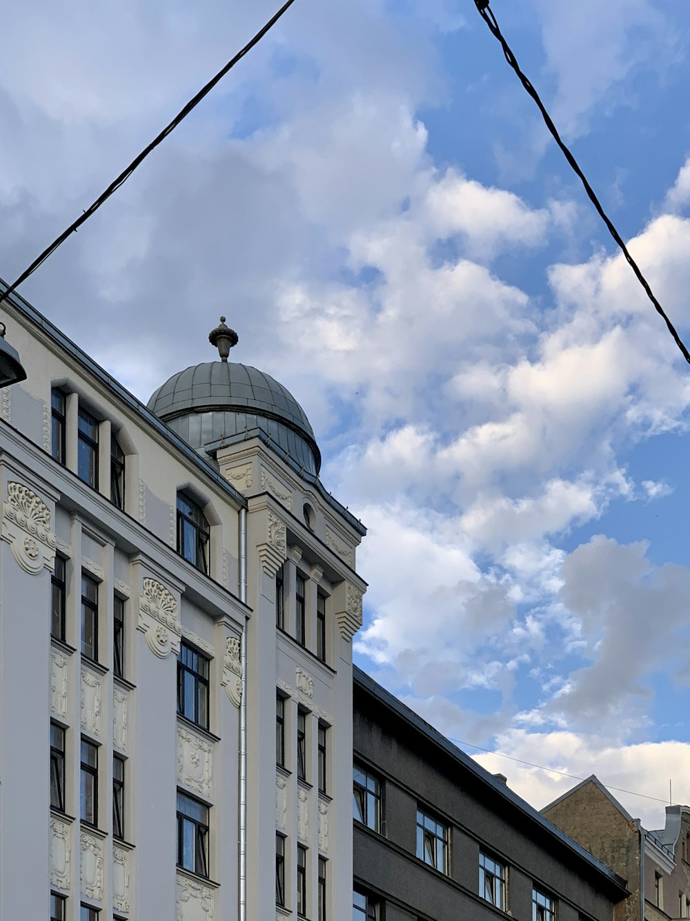 white concrete building under white clouds during daytime