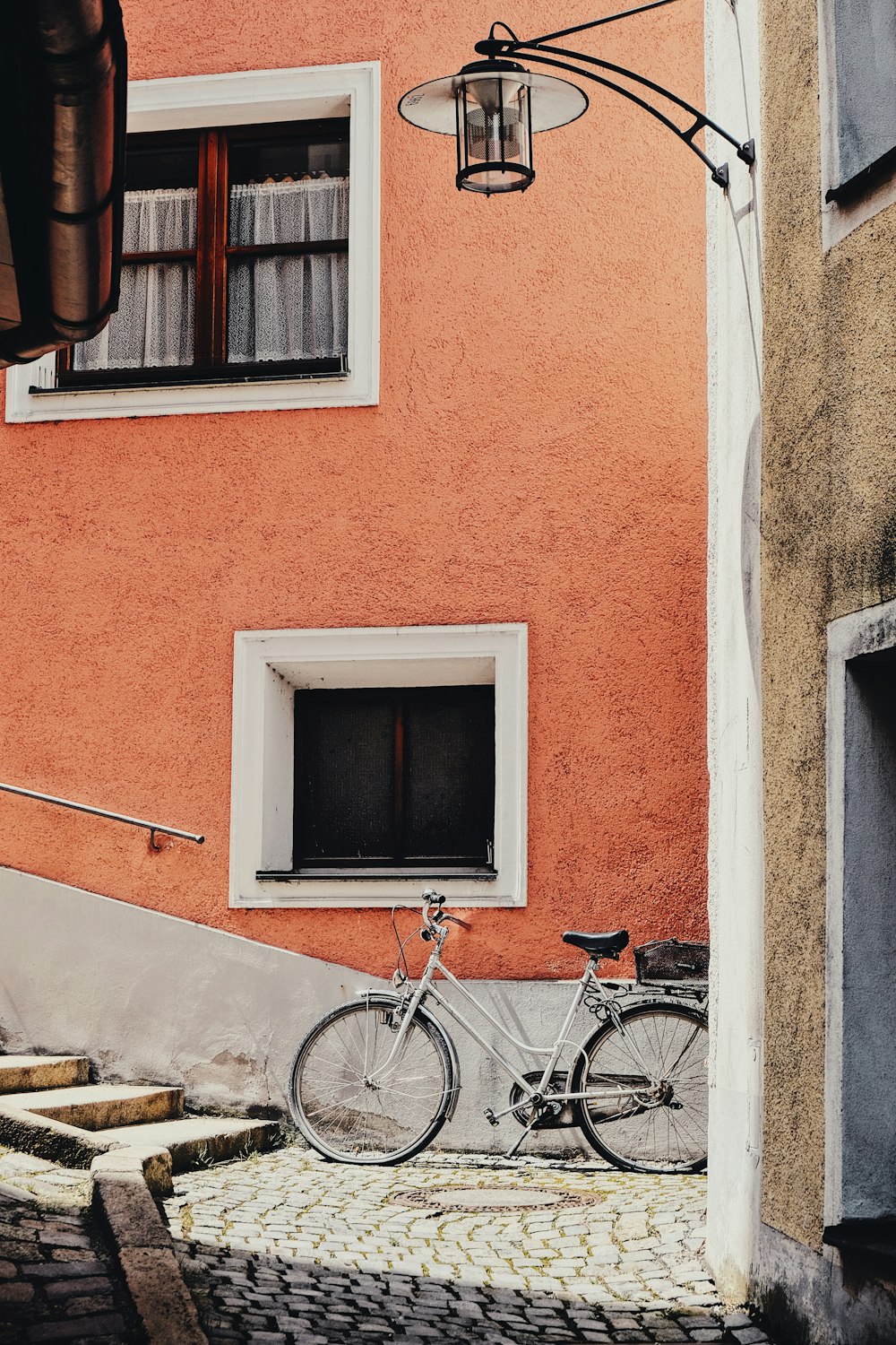 black city bike parked beside brown concrete building