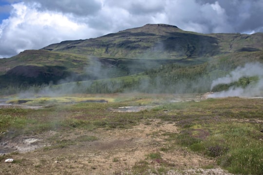 green mountain under white sky during daytime in Geysir Iceland