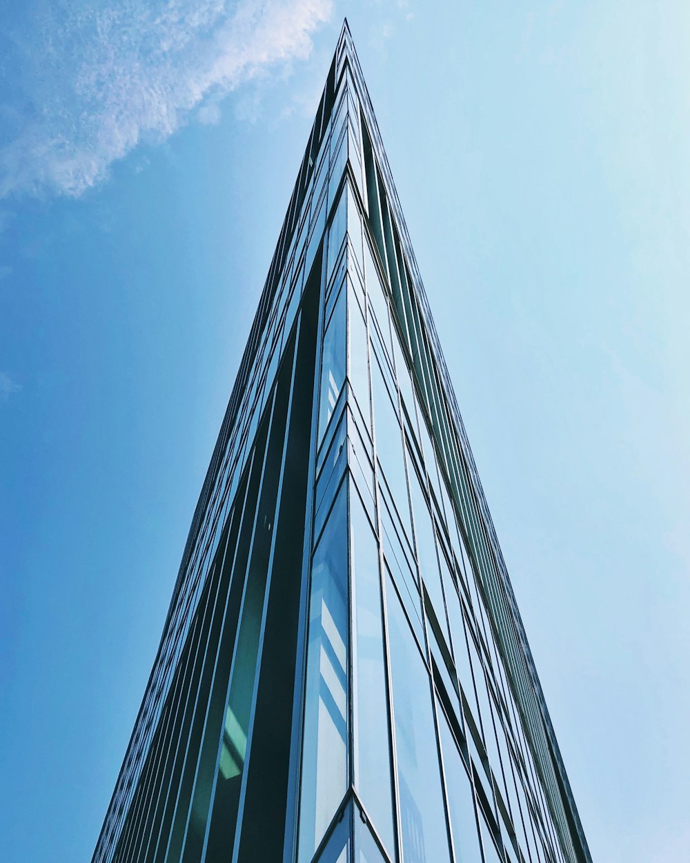 blue and white glass walled high rise building under blue sky during daytime