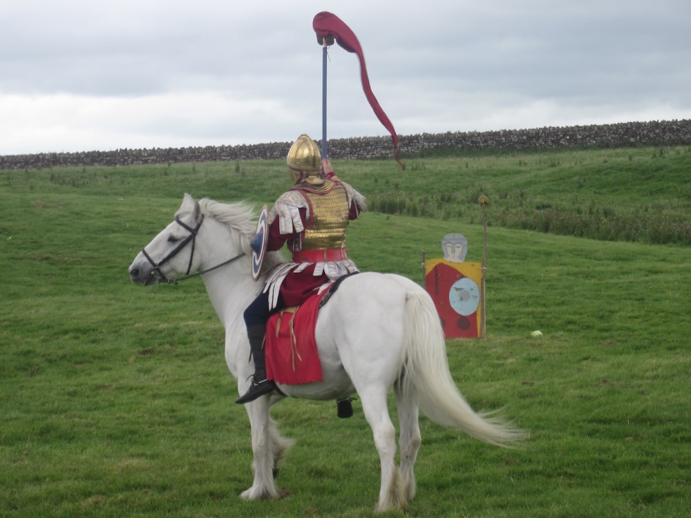 uomo in cappello bianco da cowboy che cavalca il cavallo bianco durante il giorno