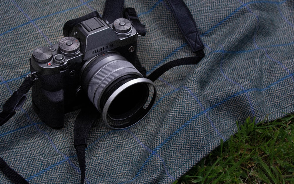 Cámara DSLR Nikon negra sobre textil azul