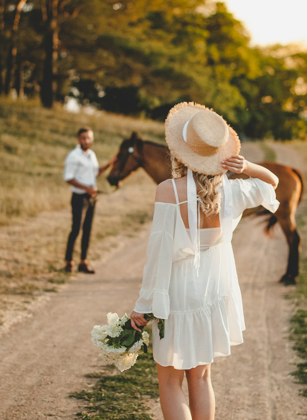 woman in white dress holding white flower bouquet