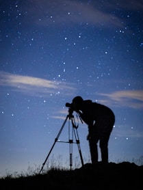 silhouette of man standing under starry night