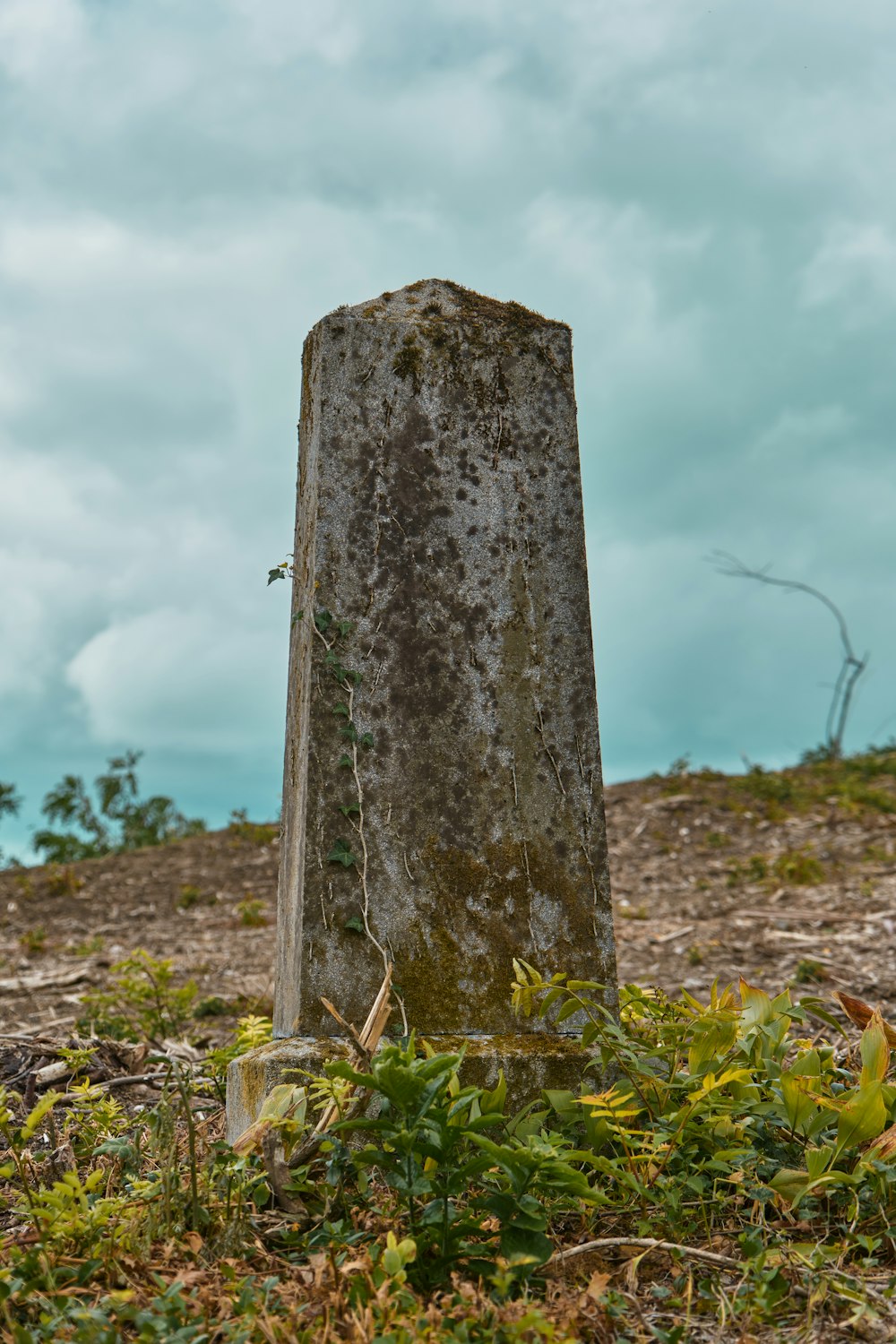 gray concrete cross on green grass during daytime